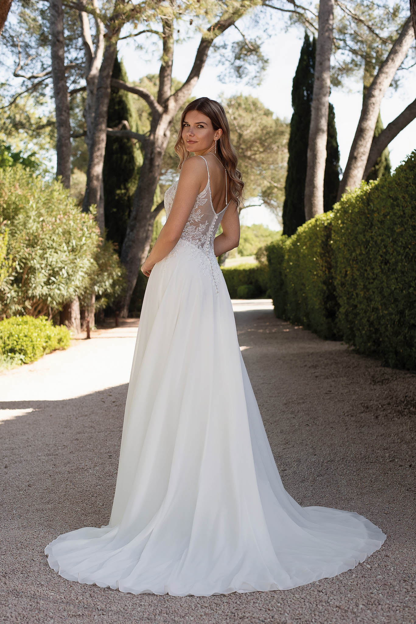 Rückenansicht eines Brautkleides mit Spitzencorsage und fließendem Rock mit Schleppe