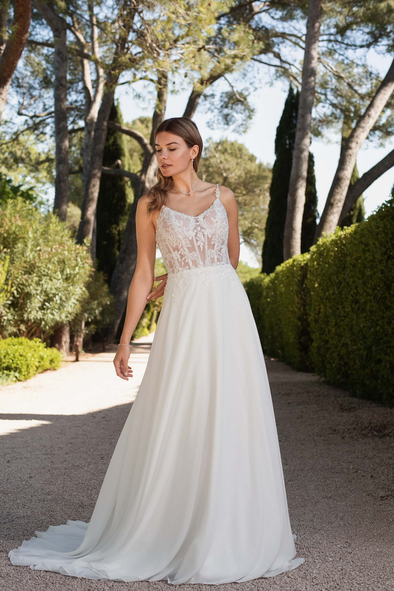 Brautkleid mit transparenter Spitzencorsage, floralen Applikationen und fließendem Rock