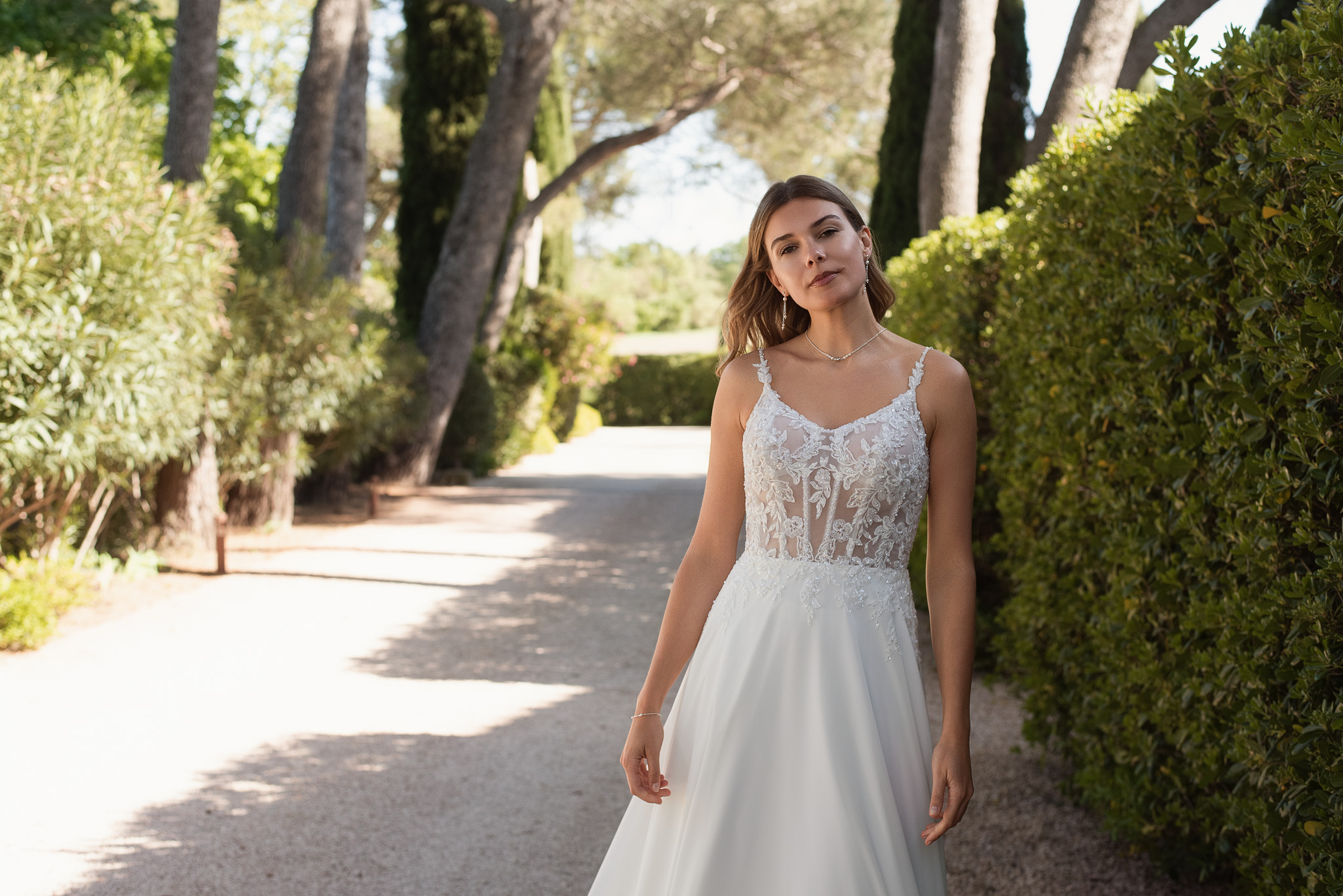 Brautkleid mit tiefem V-Ausschnitt, floraler Spitze, schmalen Trägern und fließendem Rock