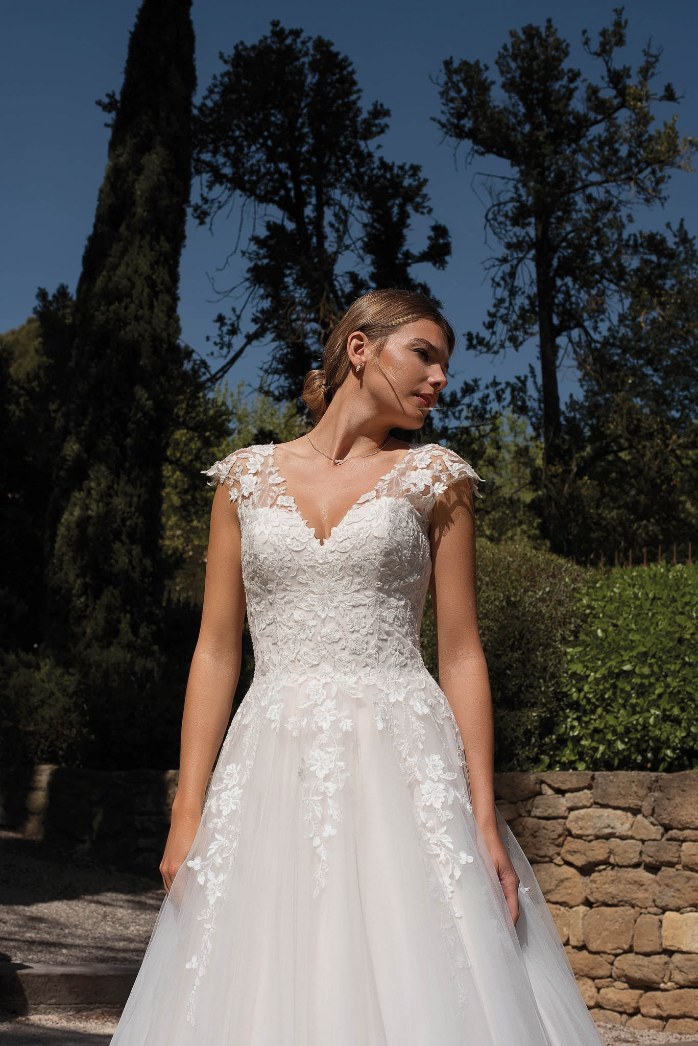Romantisches Brautkleid mit V-Ausschnitt, floralen Spitzenapplikationen und weitem Tüllrock